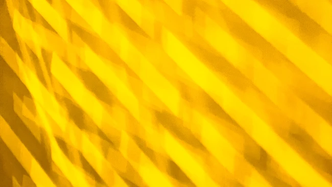 Abstract yellow diagonal lines creating a textured pattern with shadow and light variation