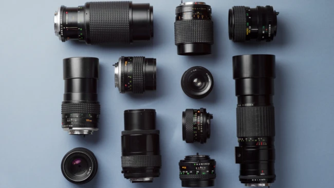 Collection of vintage camera lenses arranged symmetrically on a light blue background