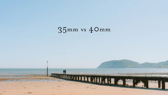 Wooden pier extending into a beach with mountains visible across the water, labeled comparing 35mm vs 40mm focal lengths.
