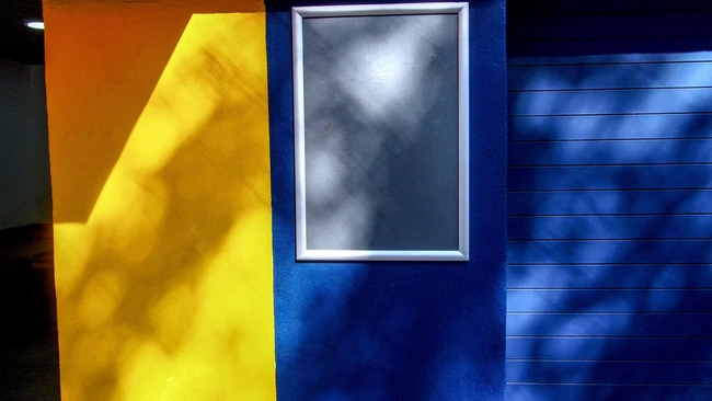 Abstract color field composition with yellow, dark blue, and neutral tones divided by geometric planes