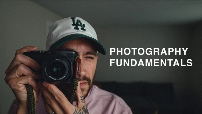 Photographer holding a Leica rangefinder camera, wearing LA Dodgers cap