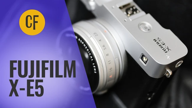 Fujifilm X-E5 mirrorless camera with interchangeable lens against purple and black background