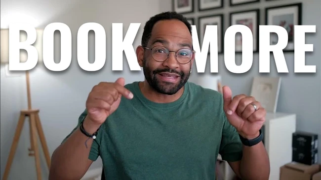 Man in green t-shirt and glasses pointing at camera with 'BOOK MORE' text overlay