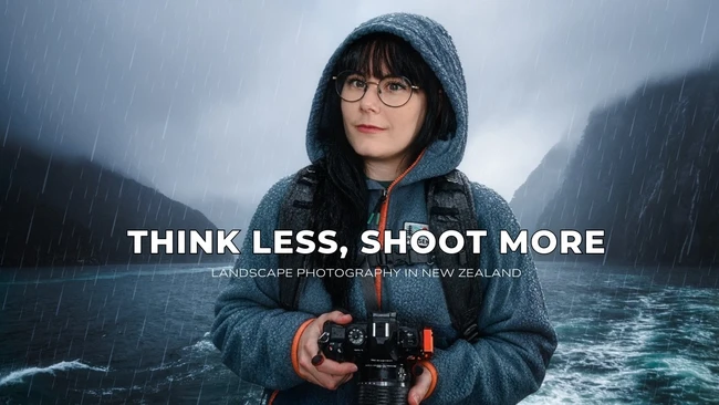 Young photographer holding a camera in heavy rain with mountainous landscape backdrop