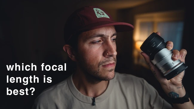 Photographer holding a telephoto lens while contemplating focal length selection