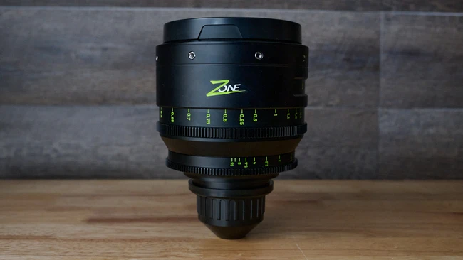 Zeiss Zone cinema lens with yellow focus markings mounted on wooden surface