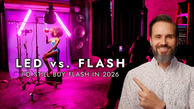 Man in light shirt pointing at studio setup with magenta LED neon lighting and professional flash equipment