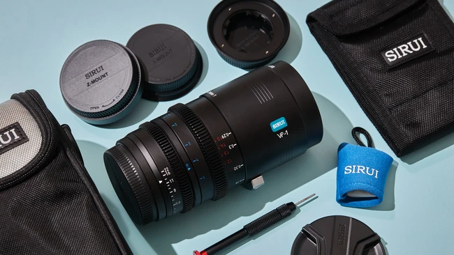 SIRUI lens and accessories laid out on light blue background with carrying cases and lens caps