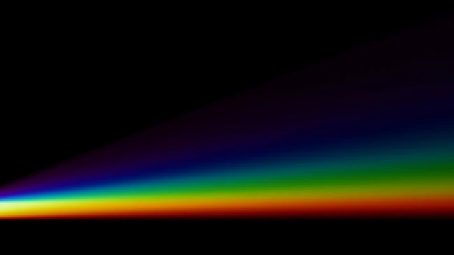 White triangular prism dispersing white light into a spectrum rainbow