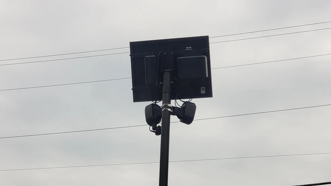 LED light panel mounted on a pole against a cloudy sky