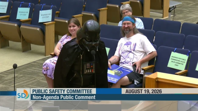 Person in Darth Vader costume speaking at Public Safety Committee meeting podium