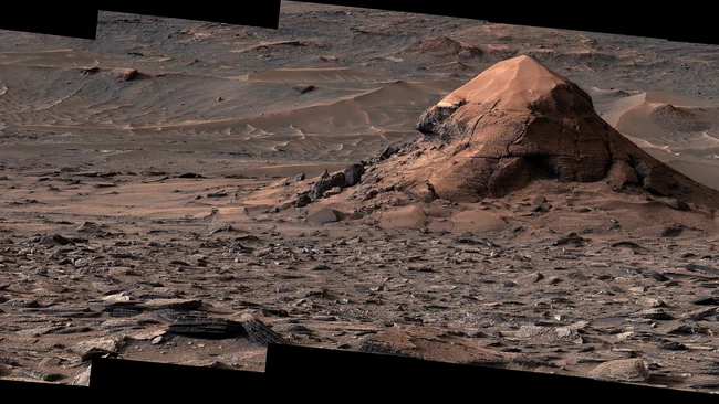 Martian landscape with conical rock formation and layered terrain under russet sky
