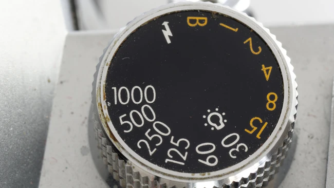 Close-up of camera aperture dial with f-stop numbers and shutter speed markings