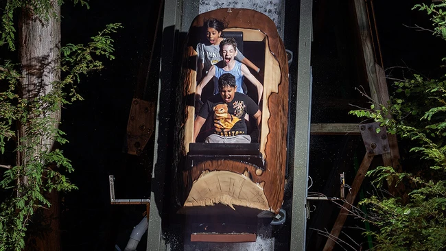 Overhead shot of four people on an amusement park ride captured from directly above