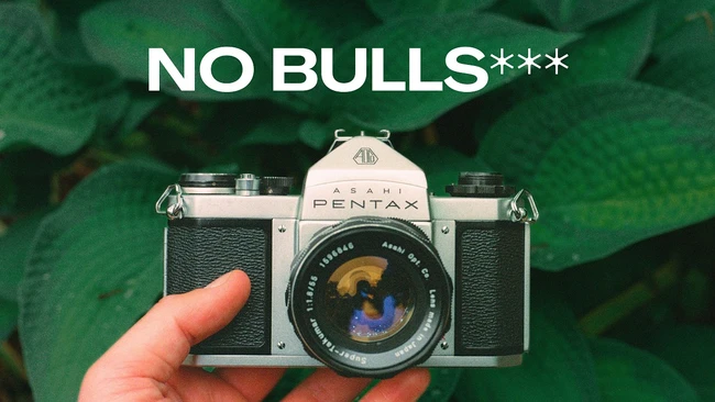Pentax film camera held in hand with text overlay reading 'NO BULLS***'