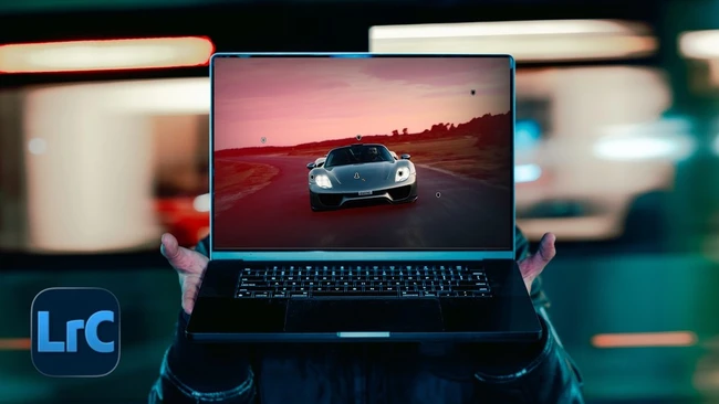Hands holding laptop displaying sports car at sunset with LrC logo visible