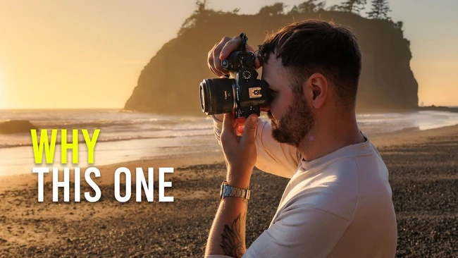 Photographer holding a mirrorless camera at beach during golden hour sunset