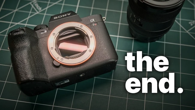 Sony Alpha mirrorless camera body without a lens on a green cutting mat, with bold white 'the end.' text overlaid on the right