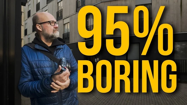 Bald bearded man in glasses and a blue puffer jacket holding a camera near a modern building, with large yellow text reading 95% BORING.