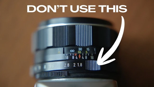 Close-up of a vintage manual focus lens's aperture ring, with a white arrow and 'DON'T USE THIS' text overlay pointing at it.