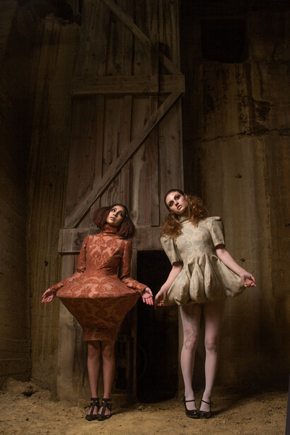 two models in couture dresses in a gold mine