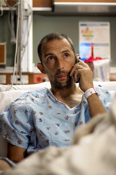 Photo of Andy Grimm watching his story on the morning news from the hospital. Photo by Caleb Perry