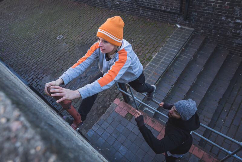 A female parkour athlete climbing a drainpipe. Andy Day.