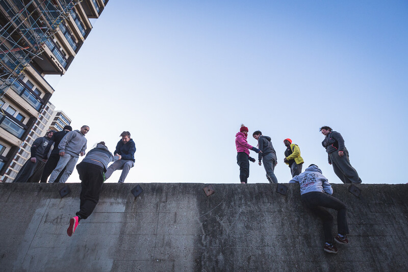 Parkour athletes gathering on the top of a wall. Andy Day.