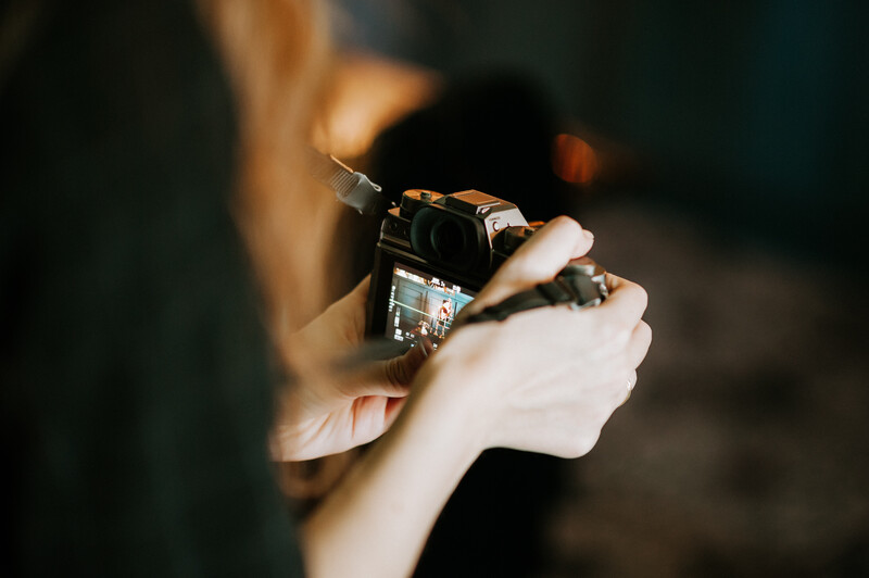 A young woman holding a digital camera.