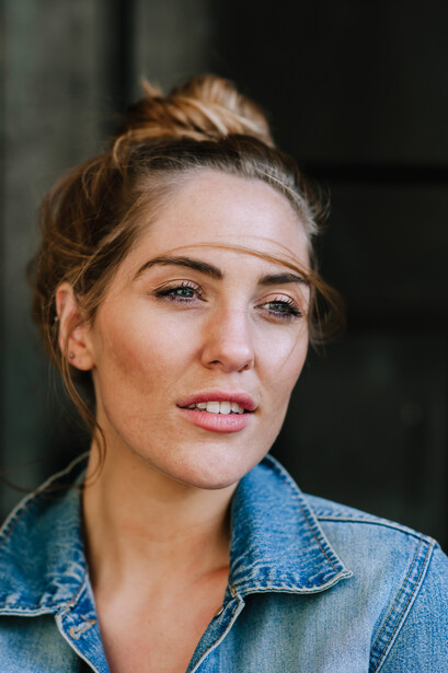 Young blonde girl in a denim jacket.