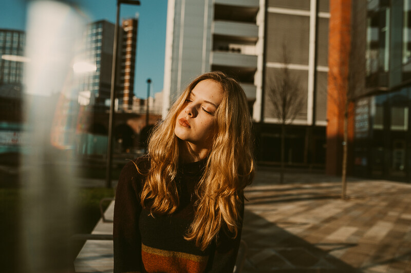 Young woman sat down in a city.