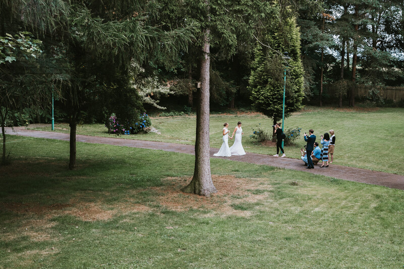 A lesbian wedding couple in a park.