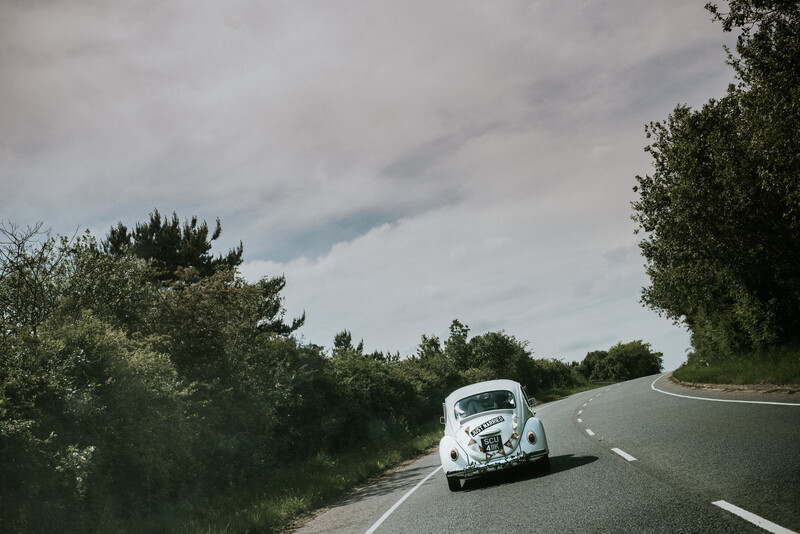 A newly married couple driving in a car.