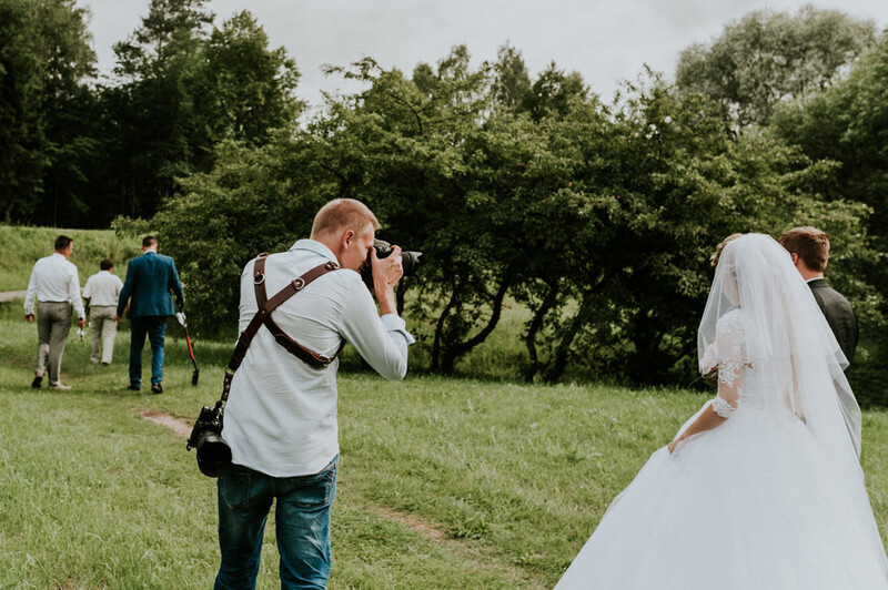 Wedding photographer shooting a couple outdoors.