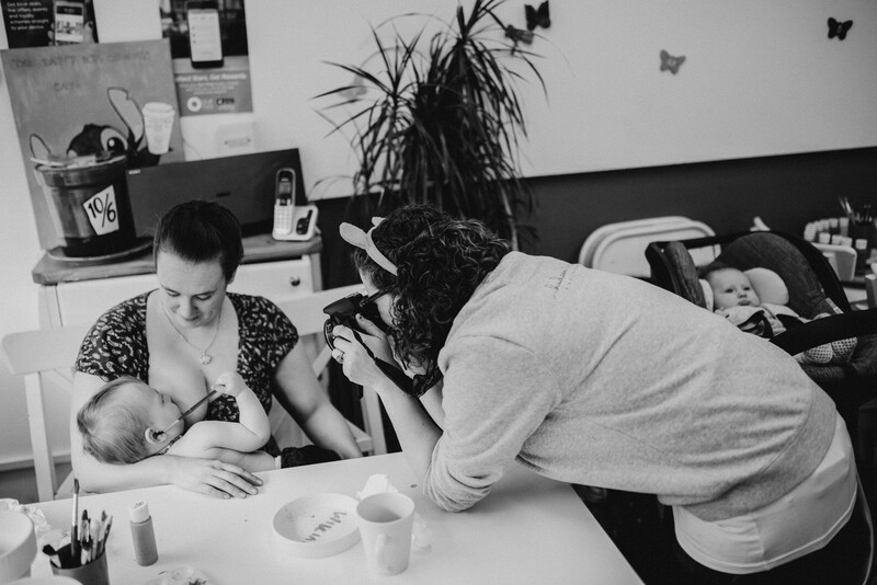 Woman breastfeeding being photographed.