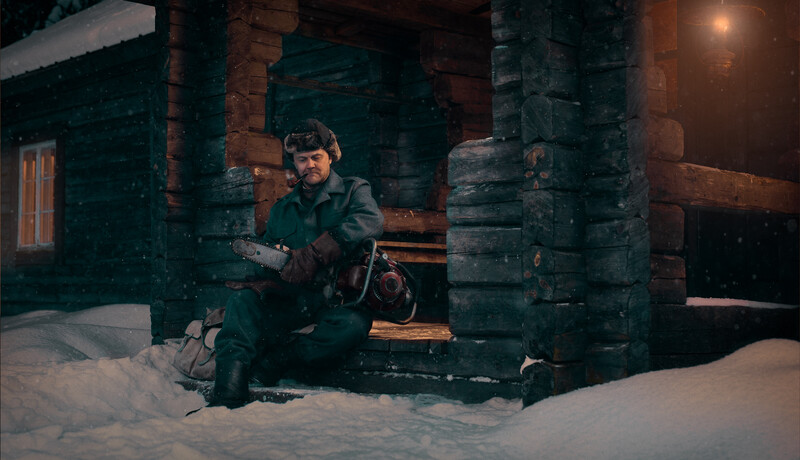 Lumberjack sat on the front of a house.