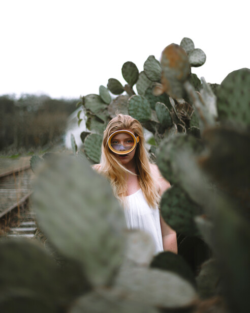 Girl stood next to cacti.