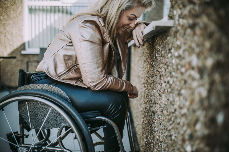 Young blond woman in a wheelchair, smiling