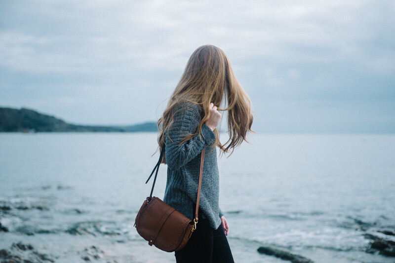 Young brown haired woman looking at the sea.