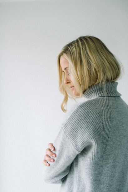 Blonde woman in a wooly jumper.