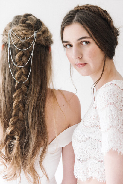 Two young brown haired women in white dresses.