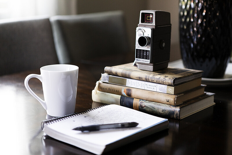 Notebook on desk with coffee and books