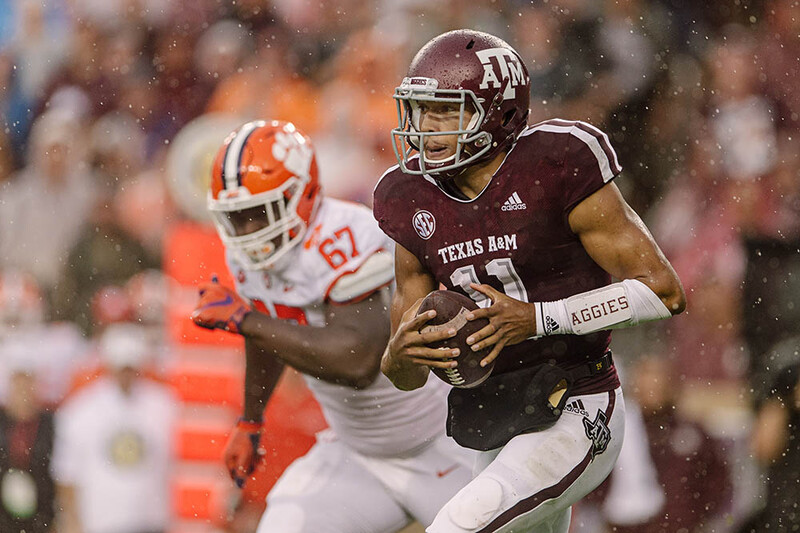 Kellen Mond of Texas A&amp;M runs in the rain against Albert Huggins of Clemson. 