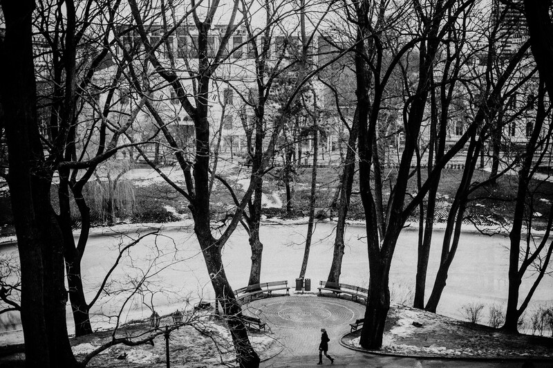 A woman walking through a park on a winter's day.