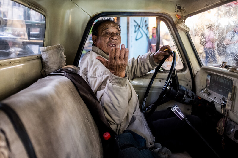 An older man in a vintage car