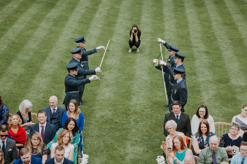 A wedding photographer crouched on the ground