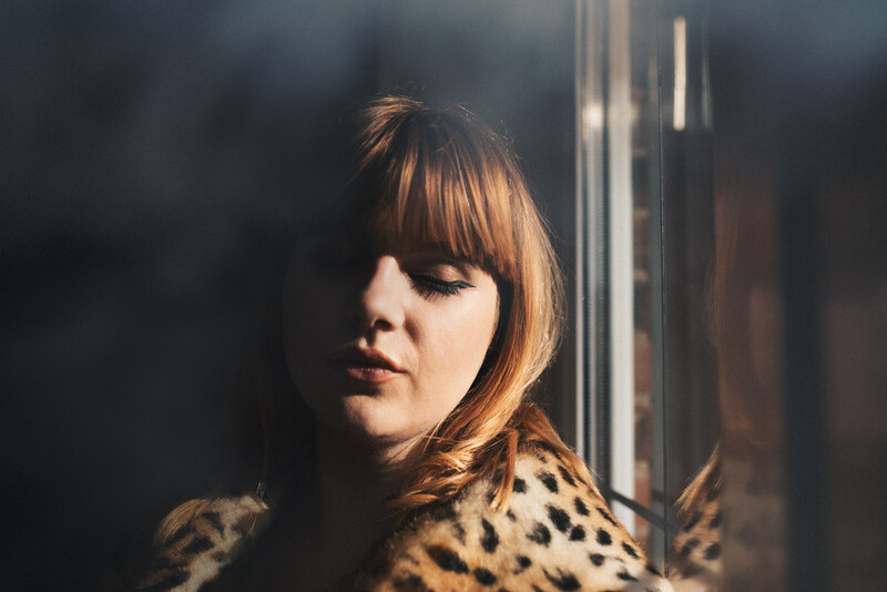 A ginger woman in a leopard print coat. 