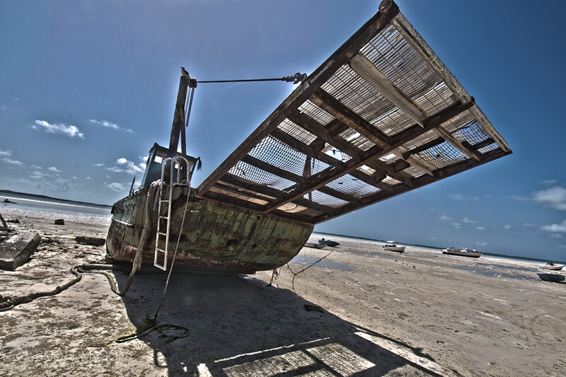 an overly-processed photo of a shipwreck on a beach