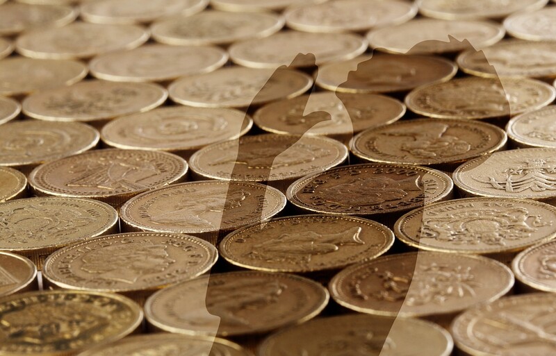 a stock photo of close-up money with the silhouette of a boy praying over it