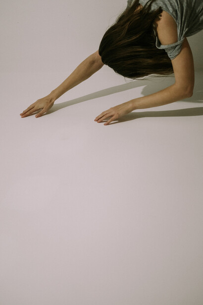 A woman holding hands up to a white wall
